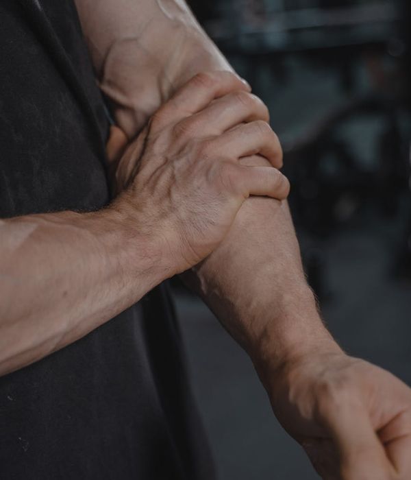 Man in a focused power stance in a dark modern gym.